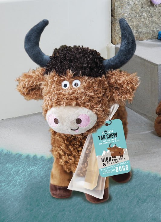 Plush toy yak with a tag labeled 'Yak Chew' on a light background