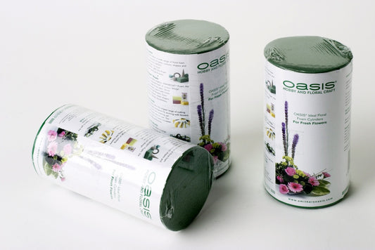 Three cylindrical Oasis floral foam packaging on a white background