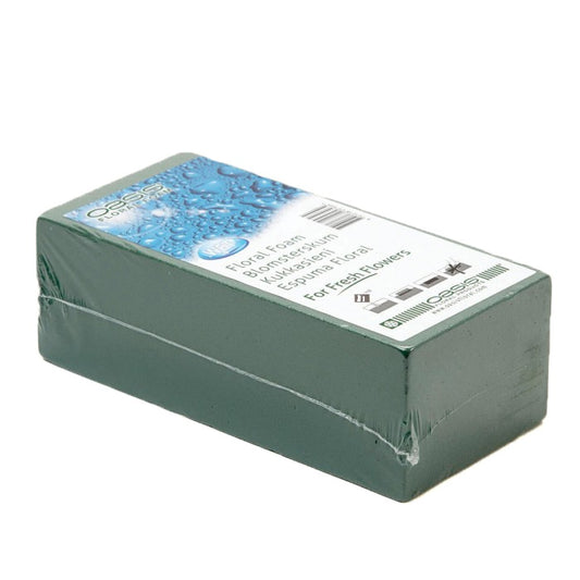Green floral foam block with a label on a white background