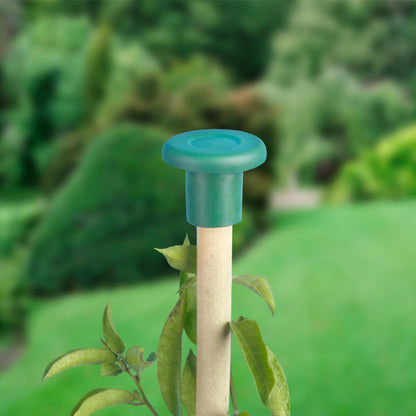 Green garden tool with wooden handle against a blurred green background