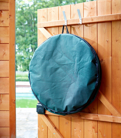 Green round bag hanging on a wooden fence