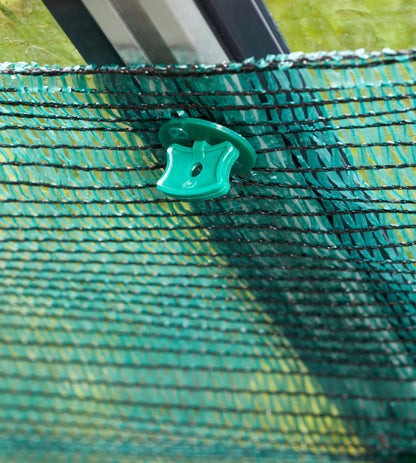 Close-up of a green mesh screen with a plastic clip on a grassy background