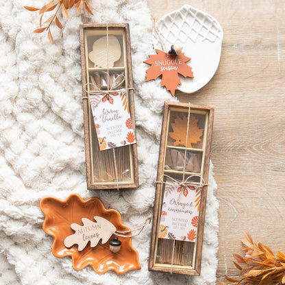 Decorative autumn-themed products including leaf-shaped containers and a tag on a textured surface.