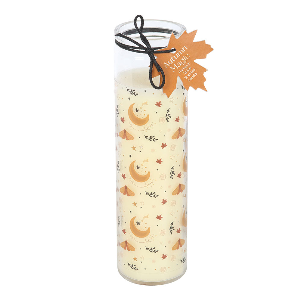 Decorative candle with moon and leaf pattern in a glass holder on a white background