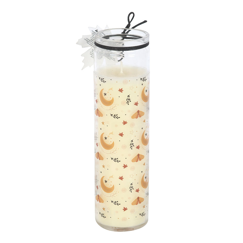 Tall glass candle with moon and leaf pattern on a white background