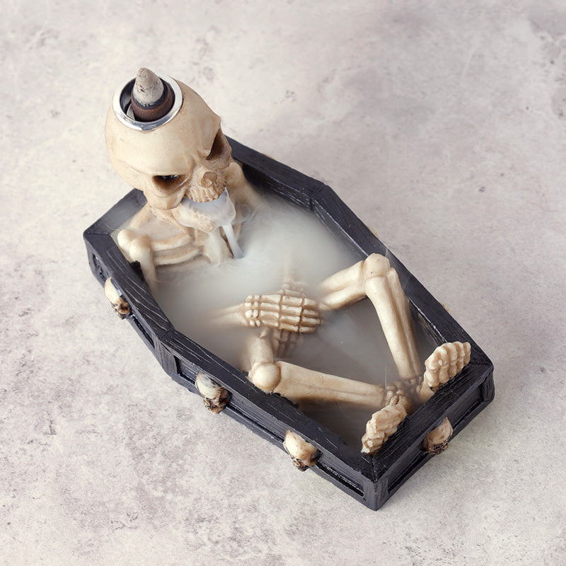 Skeletal figure in a coffin on a light gray background