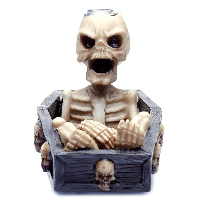 Skeleton figurine with a wooden box on a white background