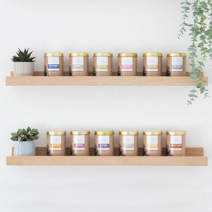 Shelves with candles and plants against a white wall