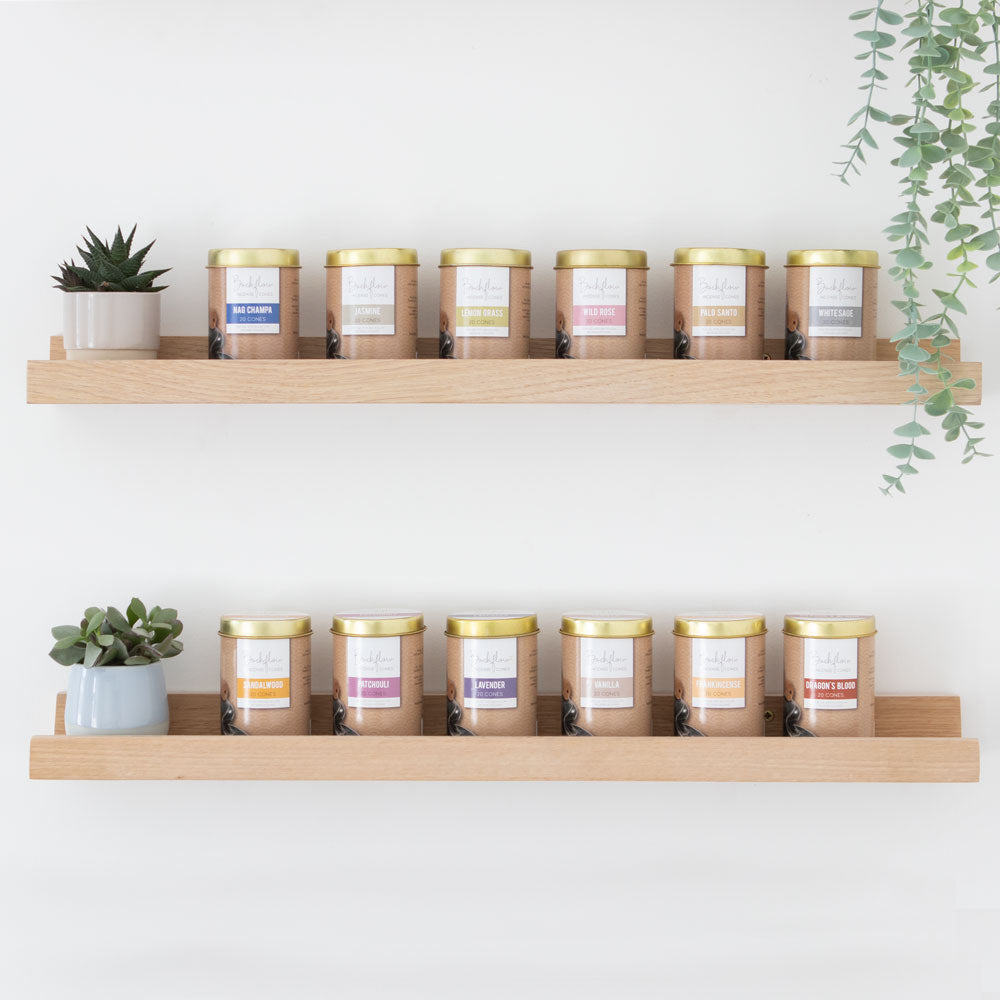 Shelves with candles and plants against a white wall