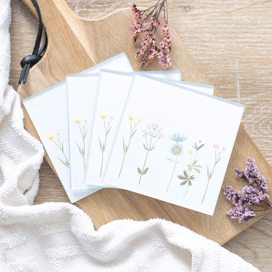 Set of greeting cards with floral designs on a wooden surface with dried flowers.