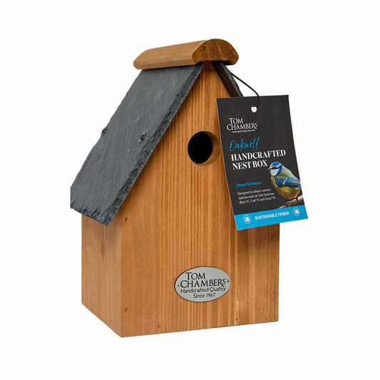 Wooden birdhouse with a slate roof and Tom Chambers label on a white background