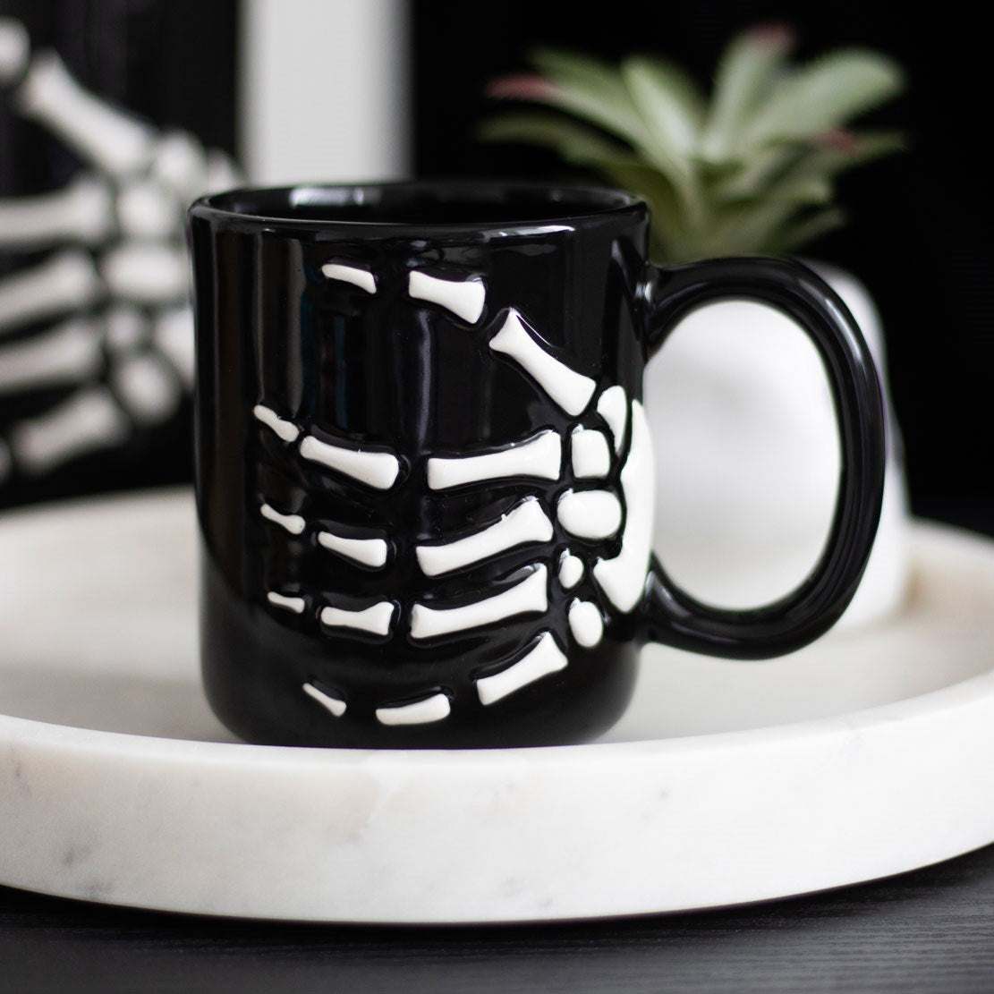 Black mug with a skeleton hand pattern