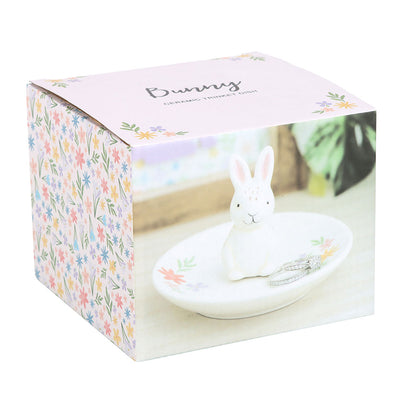 Decorative rabbit figurine on a stand with floral packaging