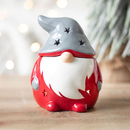 Decorative gnome figurine with a gray hat and red body on a wooden surface.