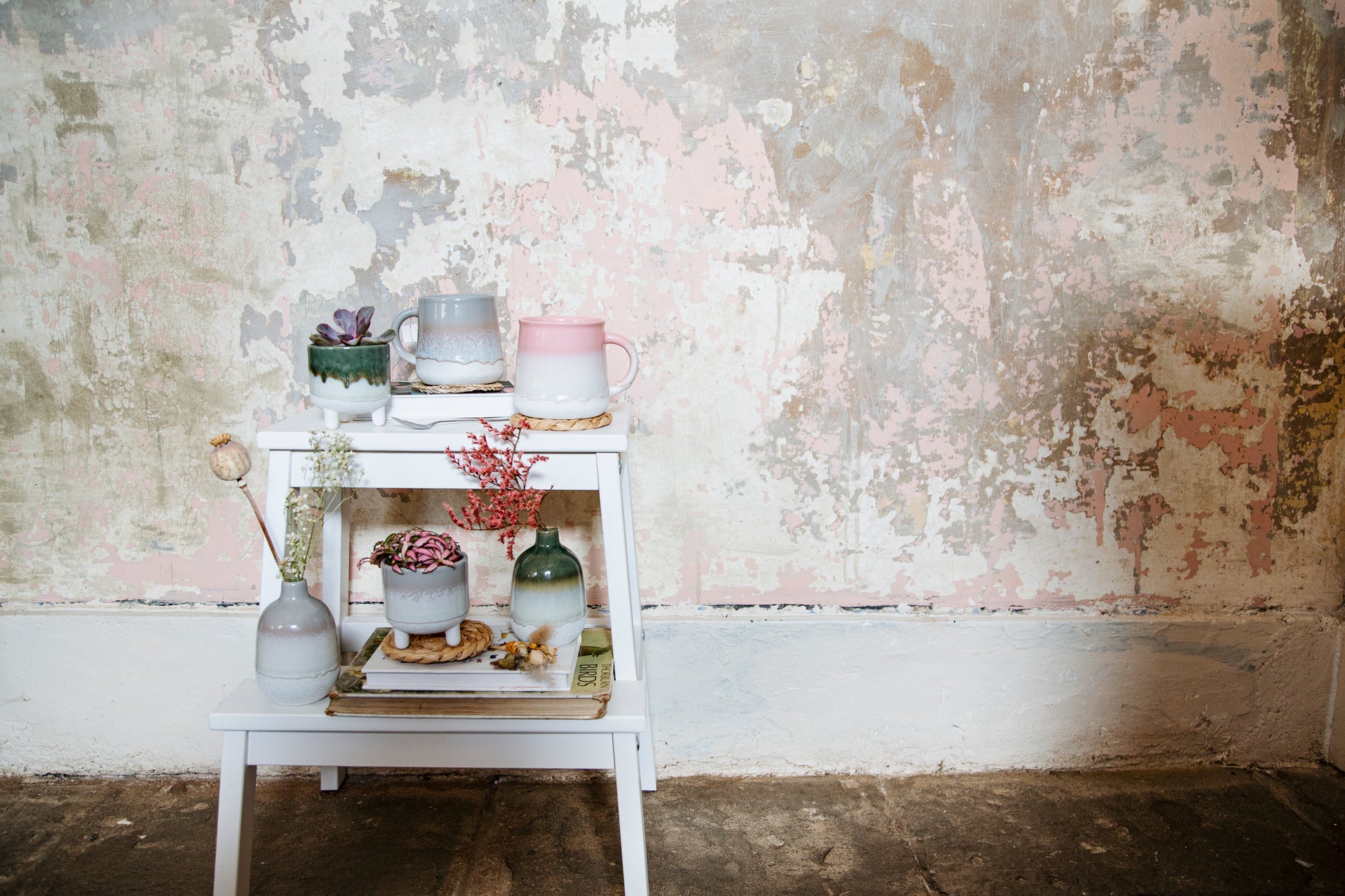 White table with decorative items against a textured wall.