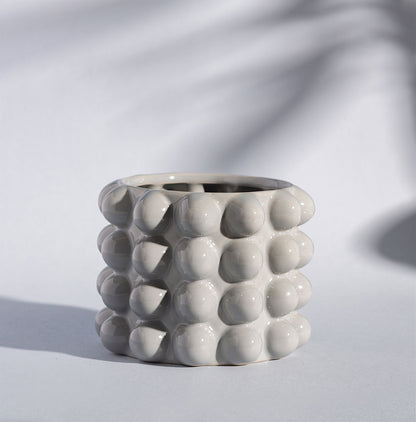 Gray textured ceramic planter on a light gray background