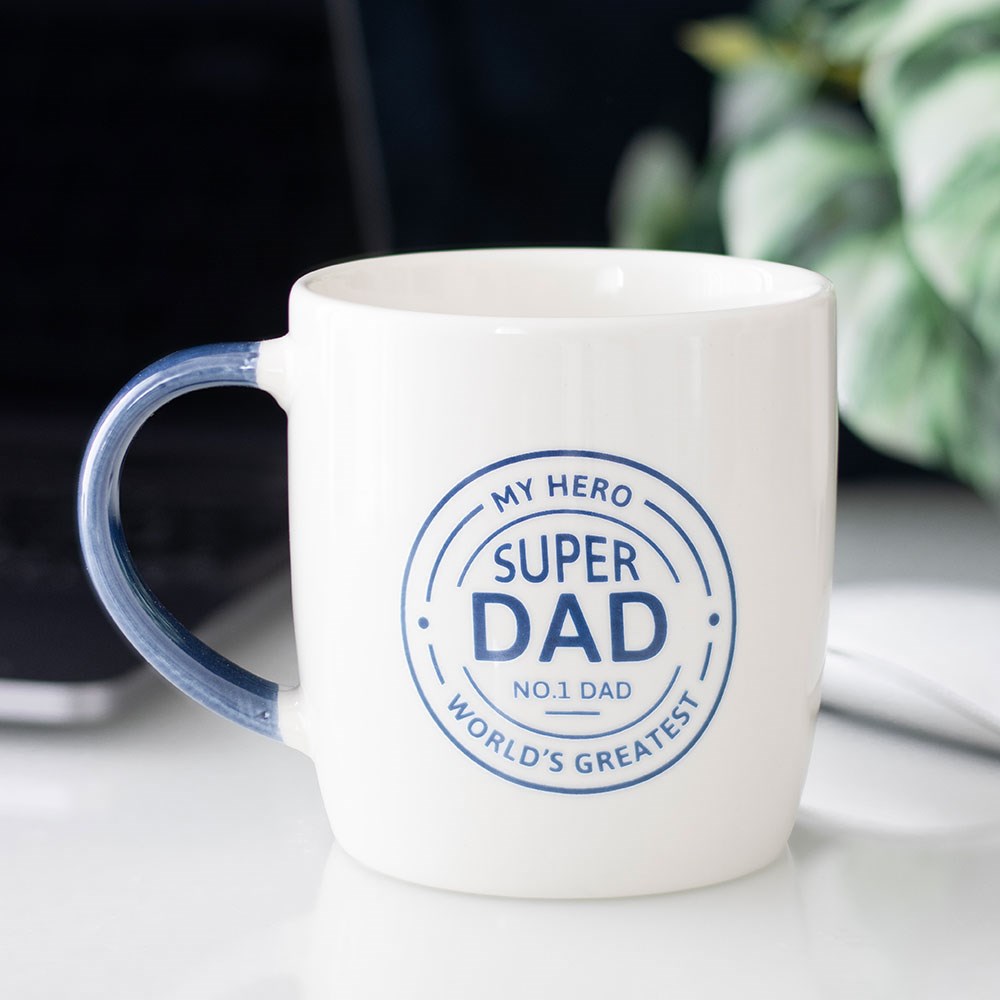 White mug with blue text 'Super Dad' on a light surface