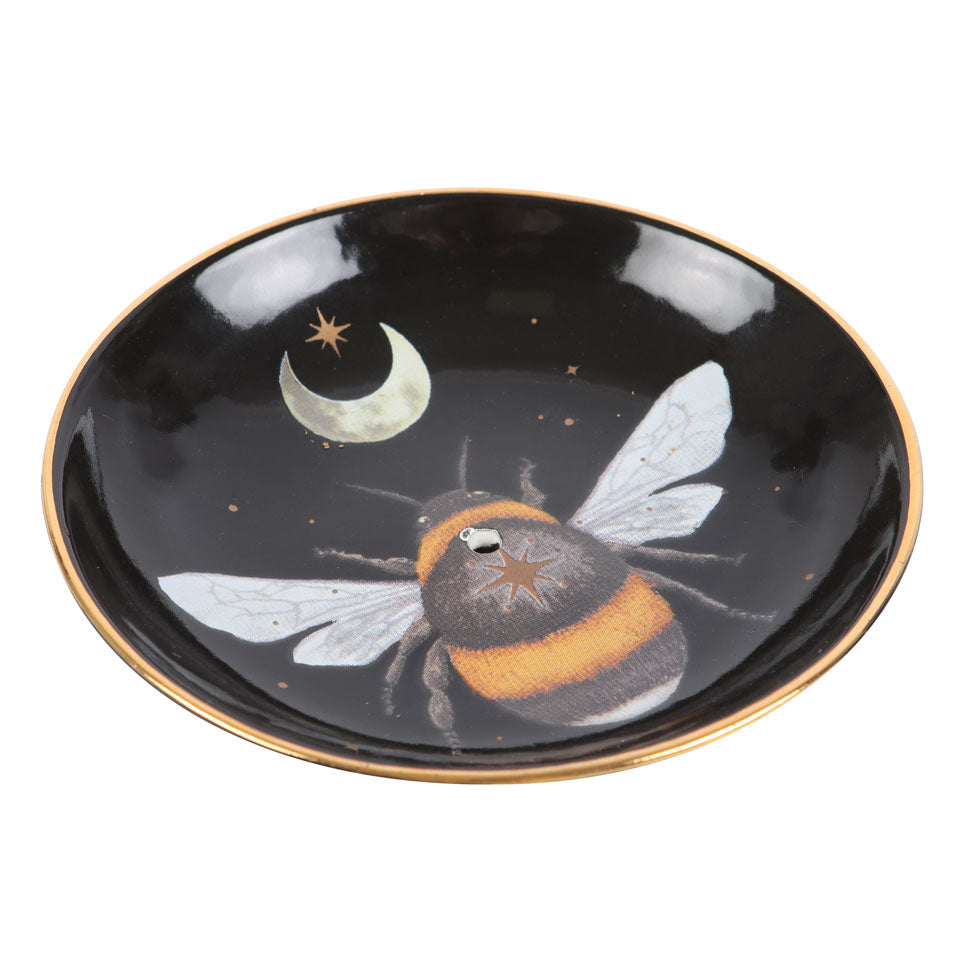 Black ceramic dish with a bee and moon design on a white background