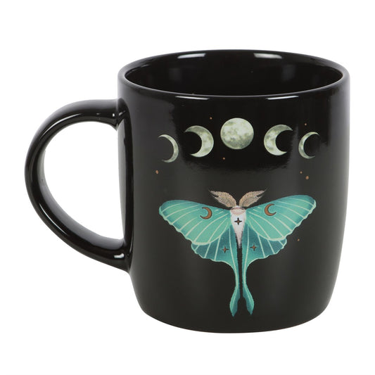 Black mug with a teal moth and moon phases design on a white background