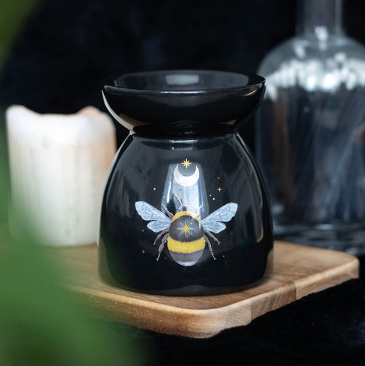 Black essential oil diffuser with bee design on a wooden surface