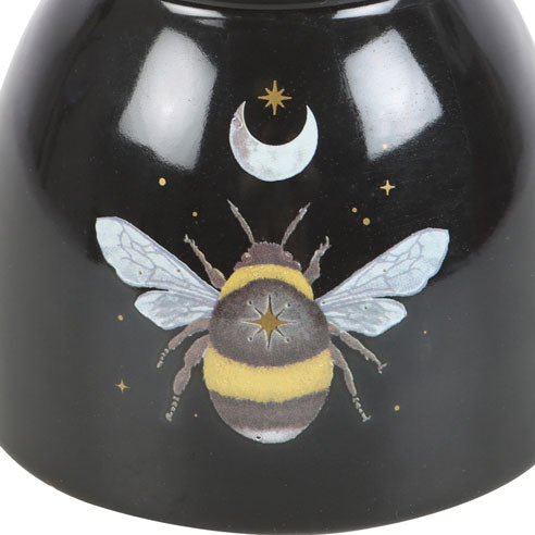 Black ceramic bowl with a bee and moon design on a white background