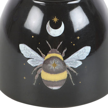 Black ceramic bowl with a bee and moon design on a white background