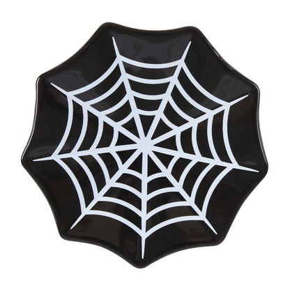 Black plate with a white spider web design on a white background