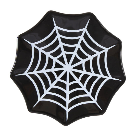 Black plate with a white spider web design on a white background