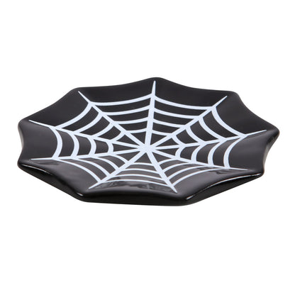 Black plate with spider web design on a white background