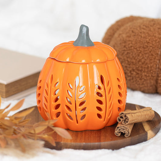 Orange ceramic pumpkin-shaped lantern with a gray top on a wooden surface.