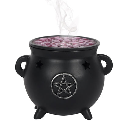 Black cauldron with a pentagram design containing pink incense balls on a white background