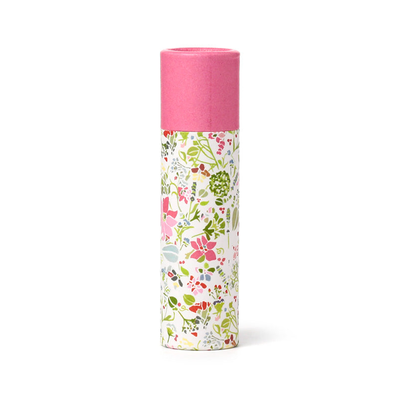 Cylindrical container with floral design on one side and pink top on the other, on a white background
