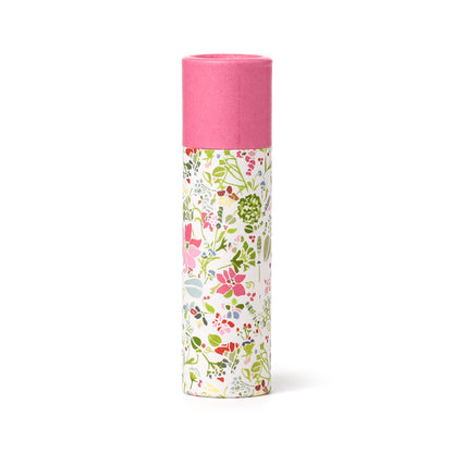Cylindrical container with floral design on one side and pink top on the other, on a white background