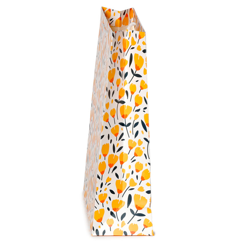 Floral patterned gift bag with yellow flowers and black leaves on a white background