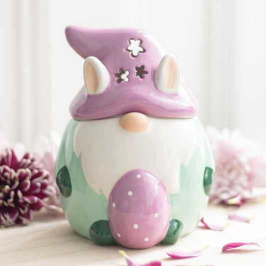 Decorative gnome with a purple hat and pink egg on a light background