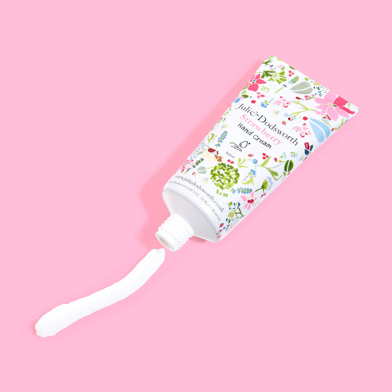 Hand cream with floral packaging on a pink background