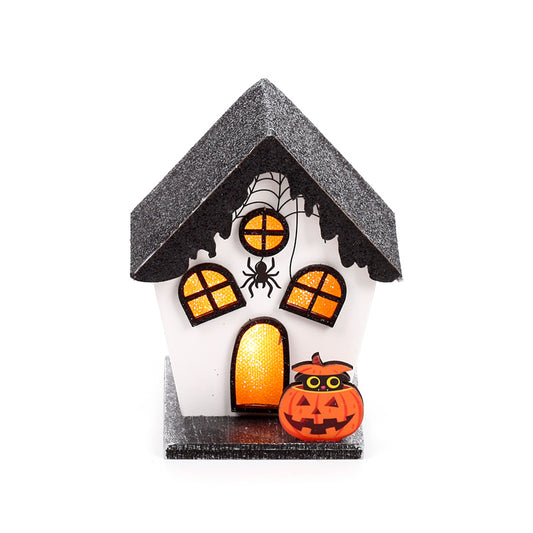 A small Halloween house decoration with a white body, glittery black roof and base, orange glowing windows, a spider on the front, and a jack-o'-lantern pumpkin next to it, shown on a plain white background.
