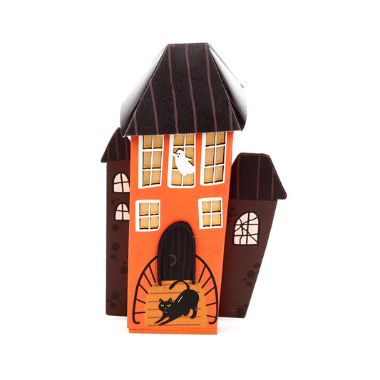 A Halloween-themed wooden house decoration with an orange front facade, dark brown roof and side towers, white window panes, a black cat silhouette at the door, and a small white ghost near a window, shown on a plain white background.
