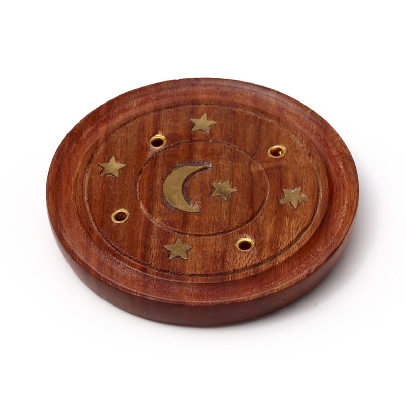 Wooden circular object with star and moon designs on a white background