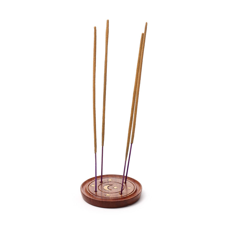 Wooden incense holder with four incense sticks on a white background