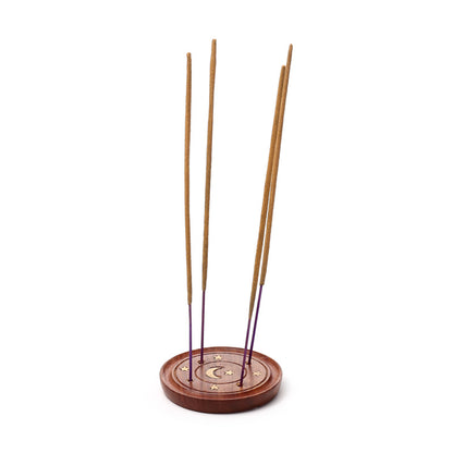 Wooden incense holder with four incense sticks on a white background