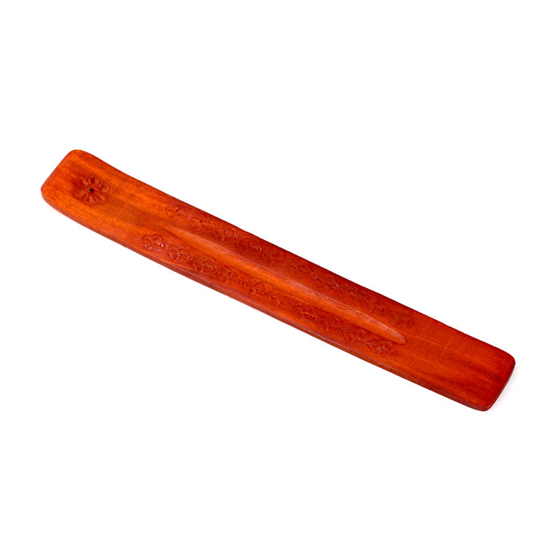 Wooden incense stick holder with floral patterns on a white background