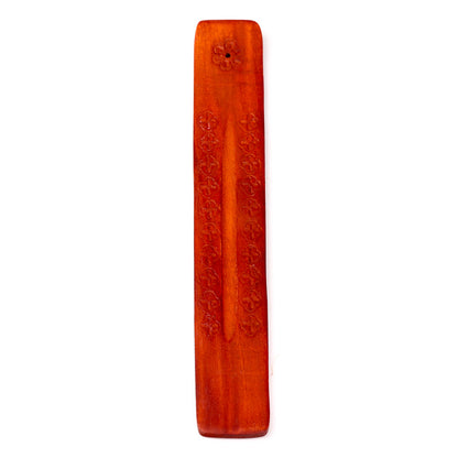 Wooden incense stick holder with engraved text on a white background