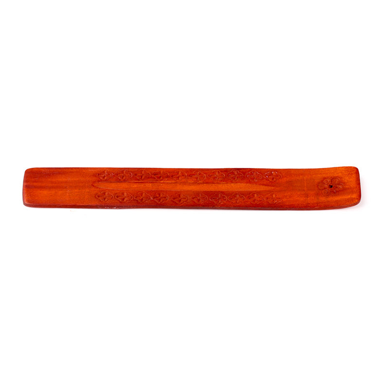 Wooden incense stick holder with intricate carvings on a white background