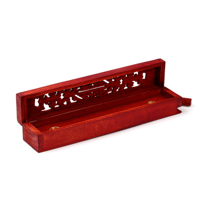 Red wooden incense holder with intricate carvings on a white background