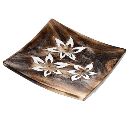 Wooden square plate with white floral designs on a white background