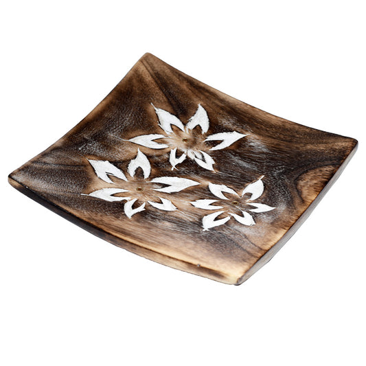 Wooden square plate with white floral designs on a white background