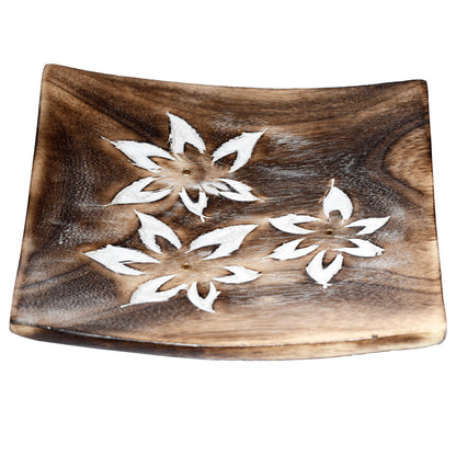Wooden tray with white floral cutouts on a white background
