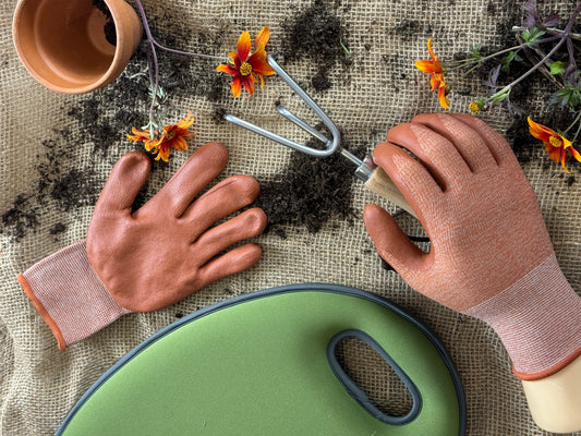 Person gardening with a trowel on a fabric surface with flowers and soil.