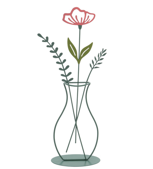 Decorative metal vase with a pink flower and green leaves on a white background